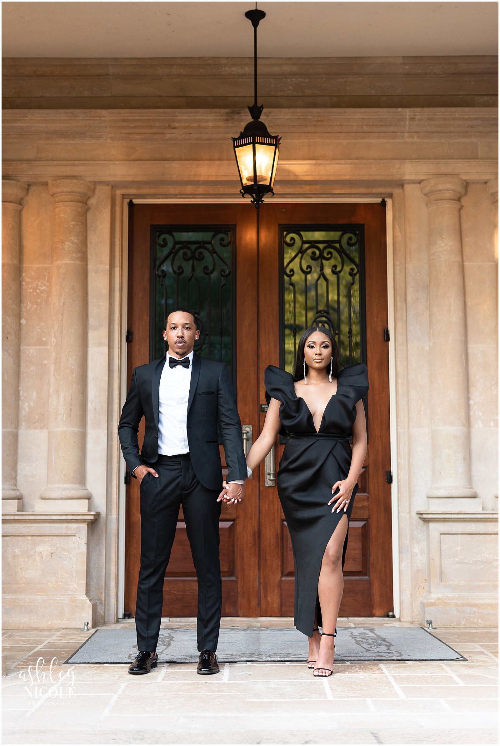 black couple holding hands in front of mansion