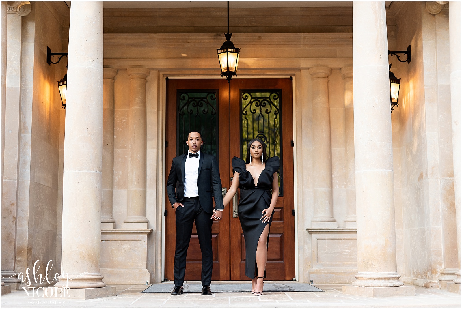 black couple holding hands standing in front of door