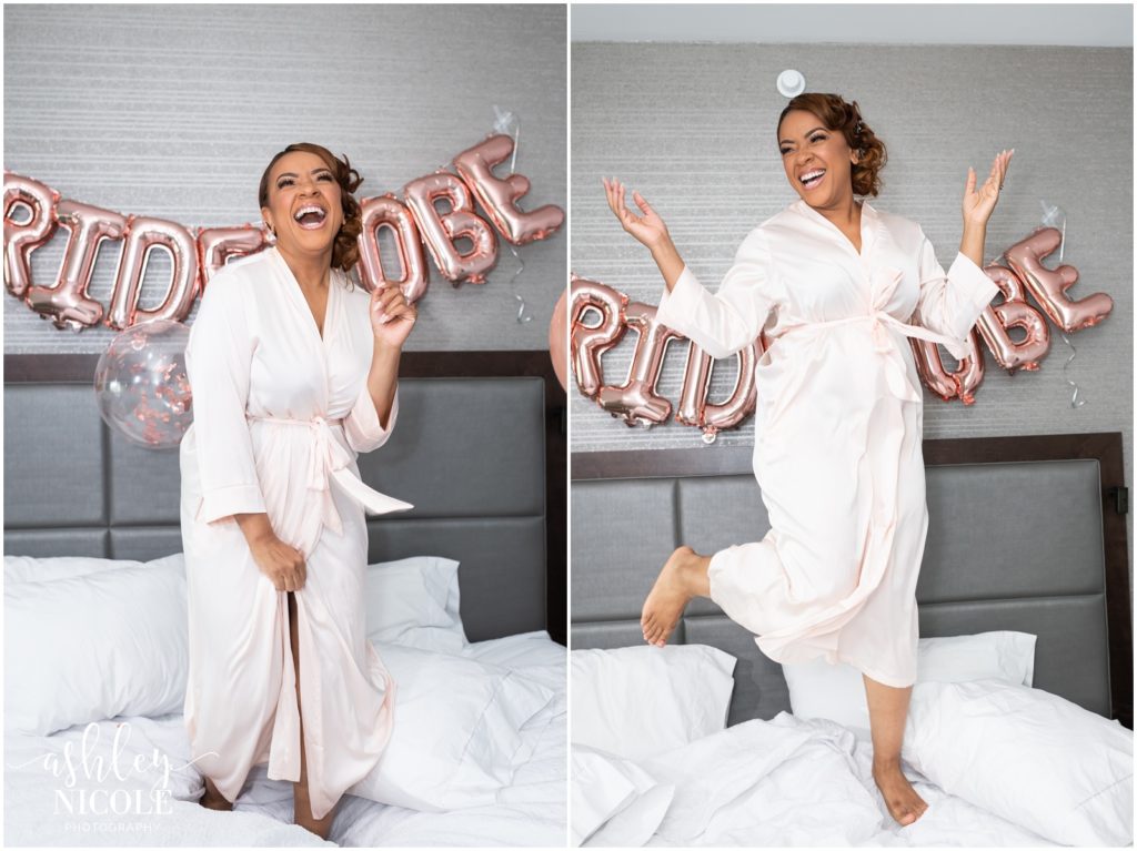 bride laughing and jumping on bed with balloons