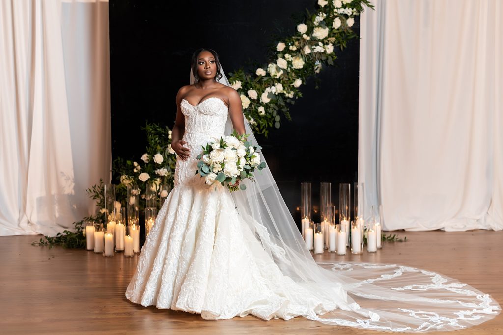 african american bride in white wedding dress in front of floral backdrop