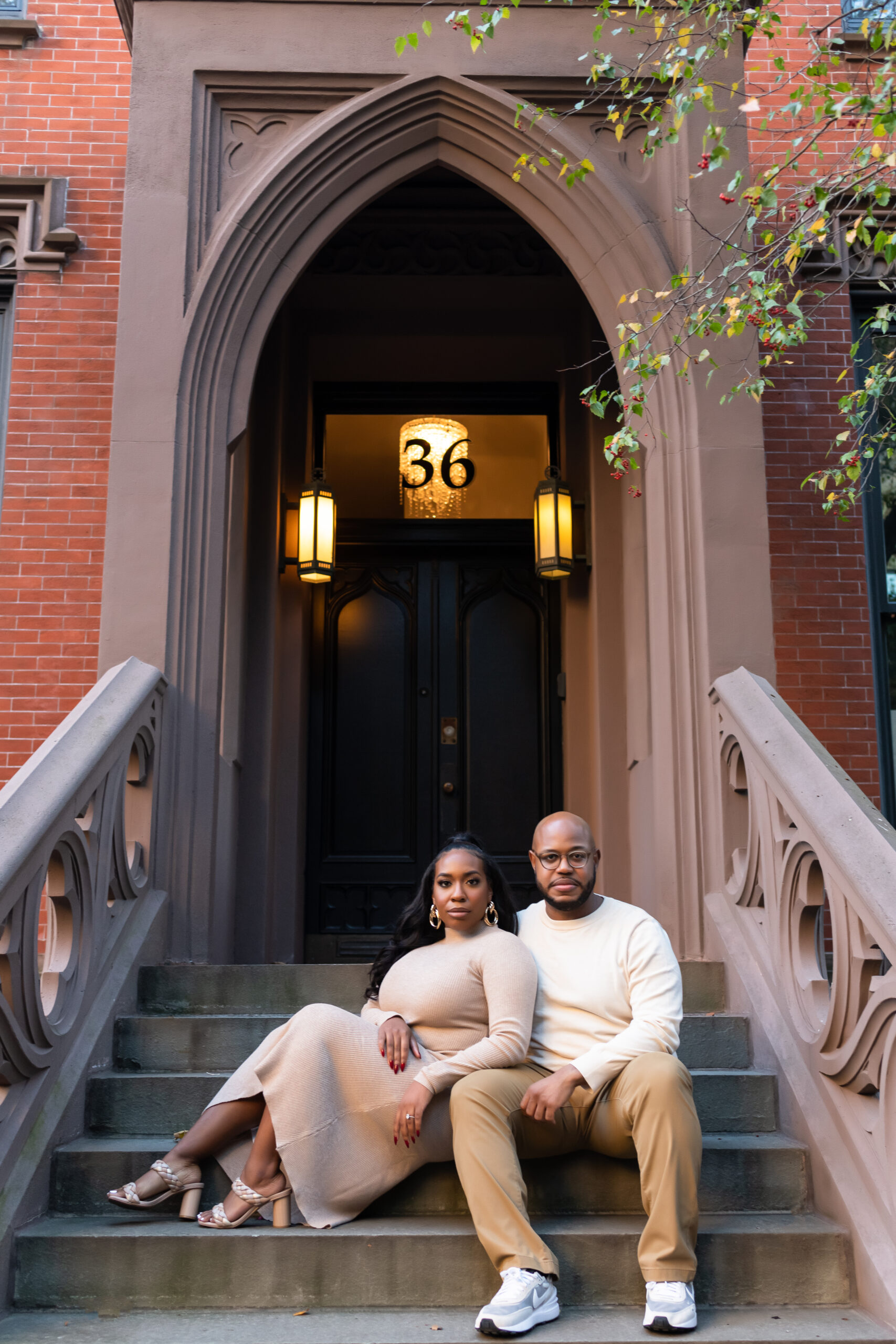 African american couple sitting on brooklyn brownstone steps smiling