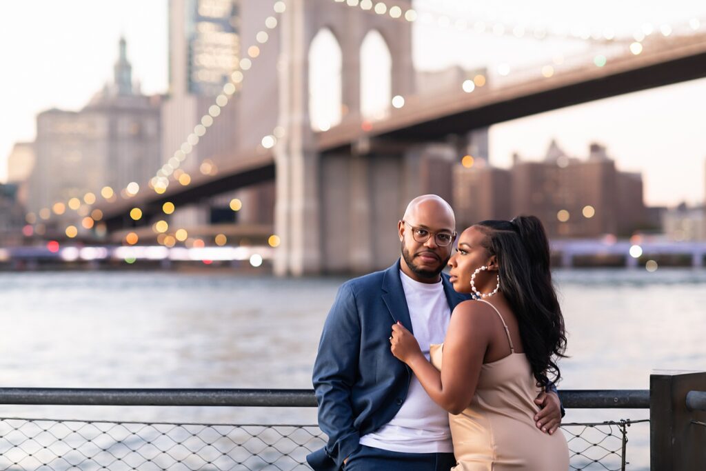 African american couple standing under Brooklyn Bridge smiling