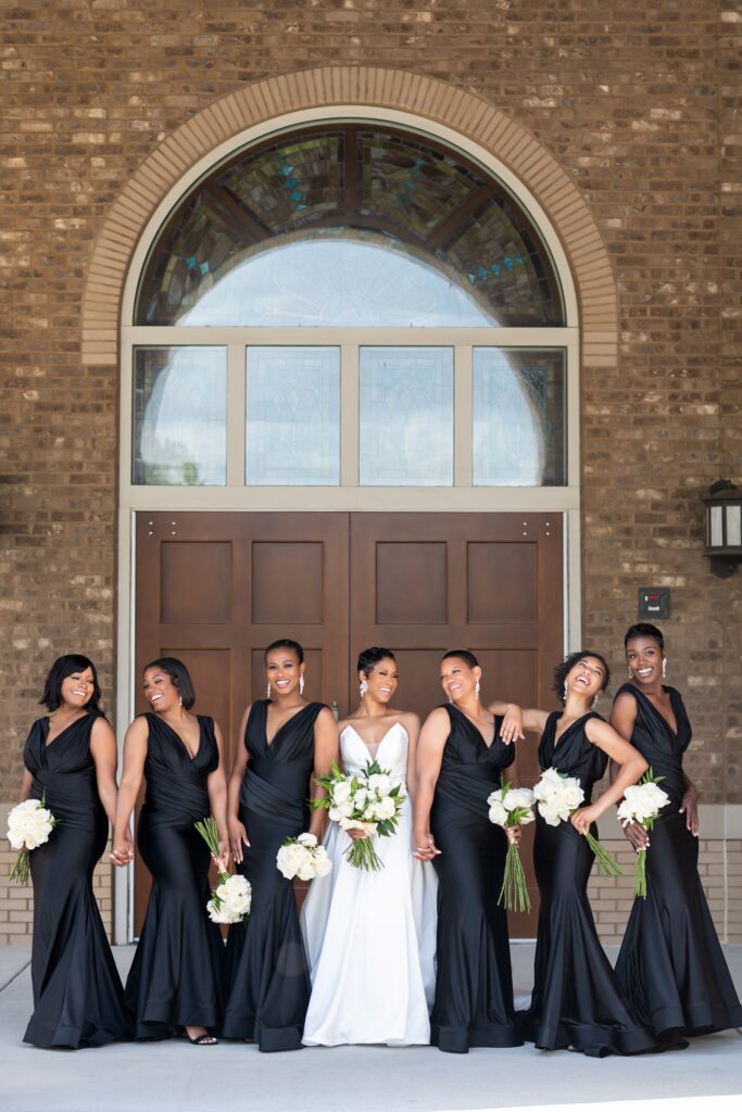 african american bride in wedding dress with bridesmaids in black dresses