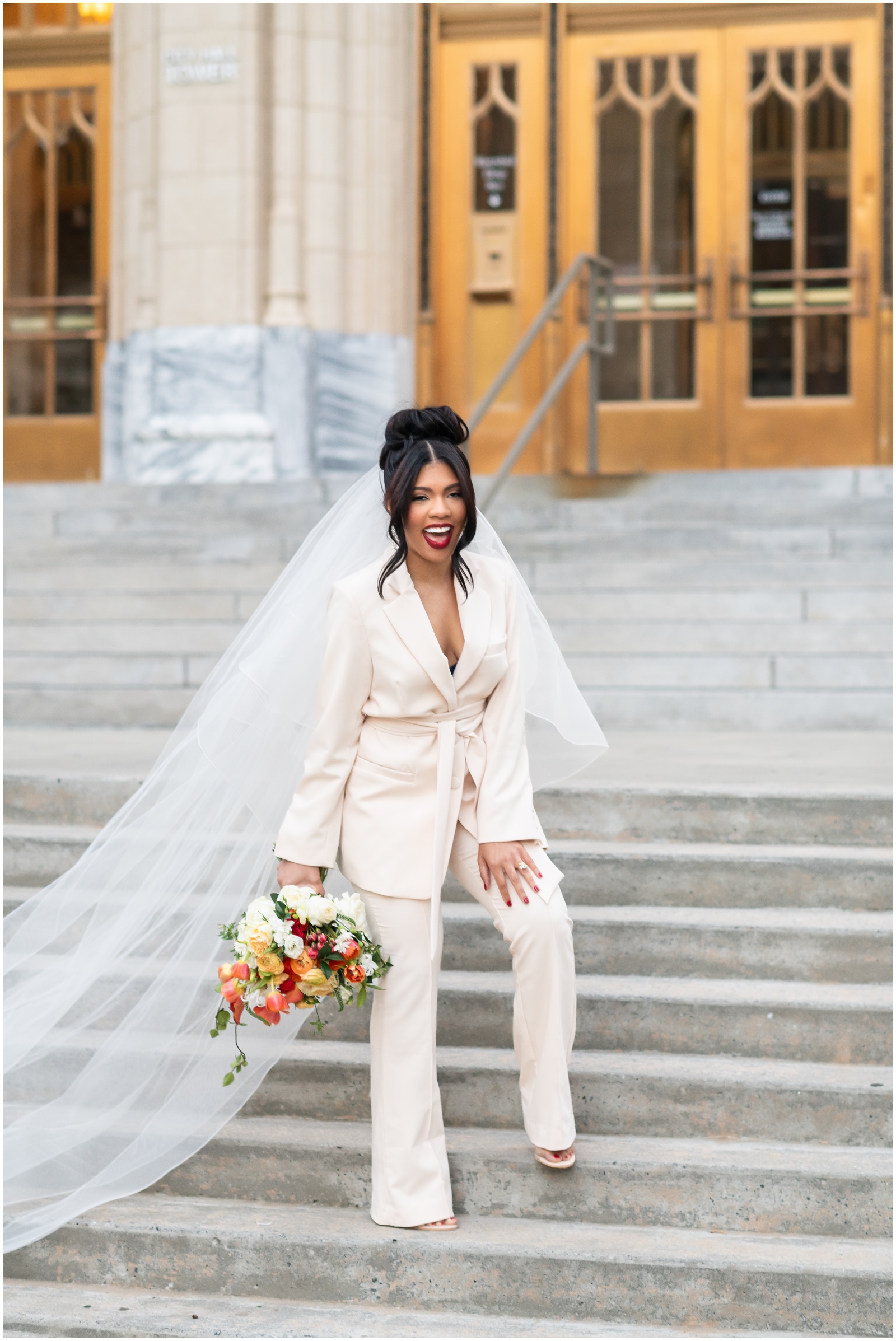 bride in white pantsuit smiling on her wedding day